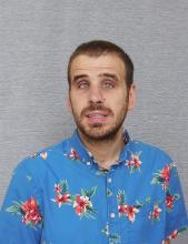 Headshot of Corey Grandstaff with short brown hair and beard in flowered blue Hawaiian shirt.