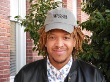 Bryson smiling outside of the Old main building wearing a WSSB hat