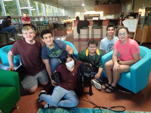 Jake, Eric A., Ferrah the therapy dog, Michelle, Molly the therapy dog, Xavier, Alijah and Nevaeh in the rec room