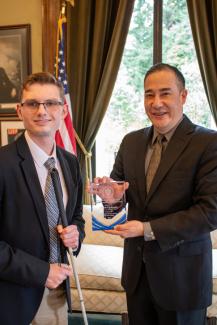 Secretary of State Steve Hobbs handing Charles an award