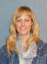 Headshot of DeEtte, a young middle aged white woman with long blonde hair and a content yet silently enthusiastic smile.