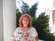 Sheryl Howe, a middle aged woman with a great head of wavy red hair smiling