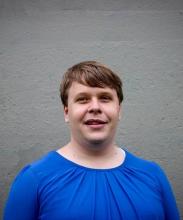 A headshot of Shane in front of a brick wall.