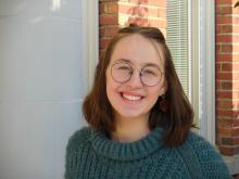 Kailee standing outside of the Old Main building smiling.