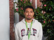 Javier standing outside of the Old Main building smiling