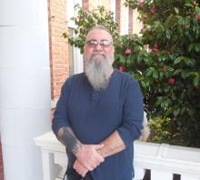 Jeff standing outside of the Old Main building smiling