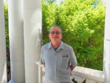 Richard is standing outside of the Old Main building smiling